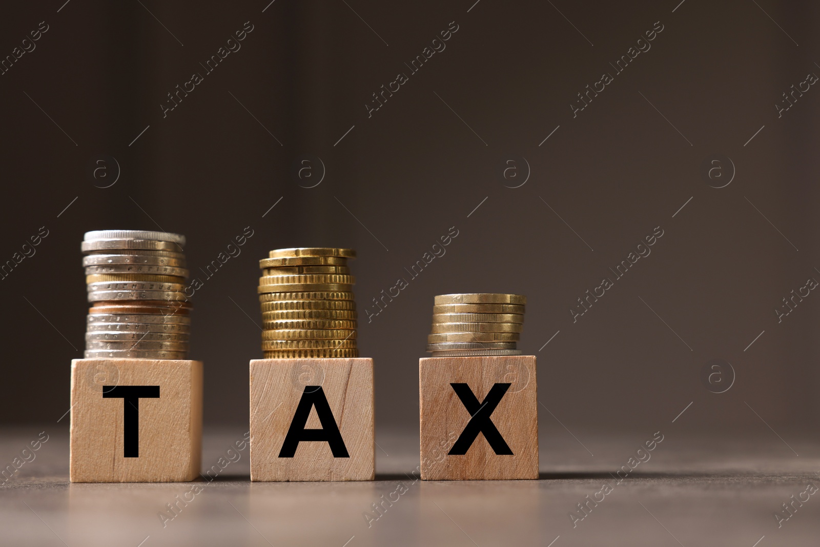 Photo of Word Tax made of wooden letters and coins on grey table, space for text