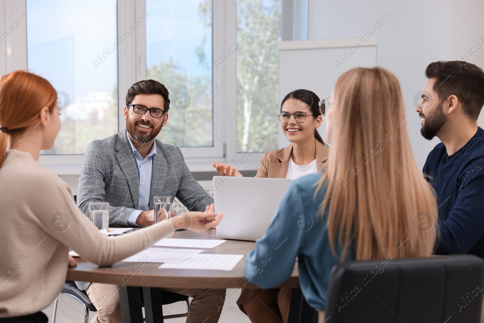 Photo of Team of employees working together in office