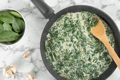 Photo of Tasty spinach dip on white marble table, flat lay