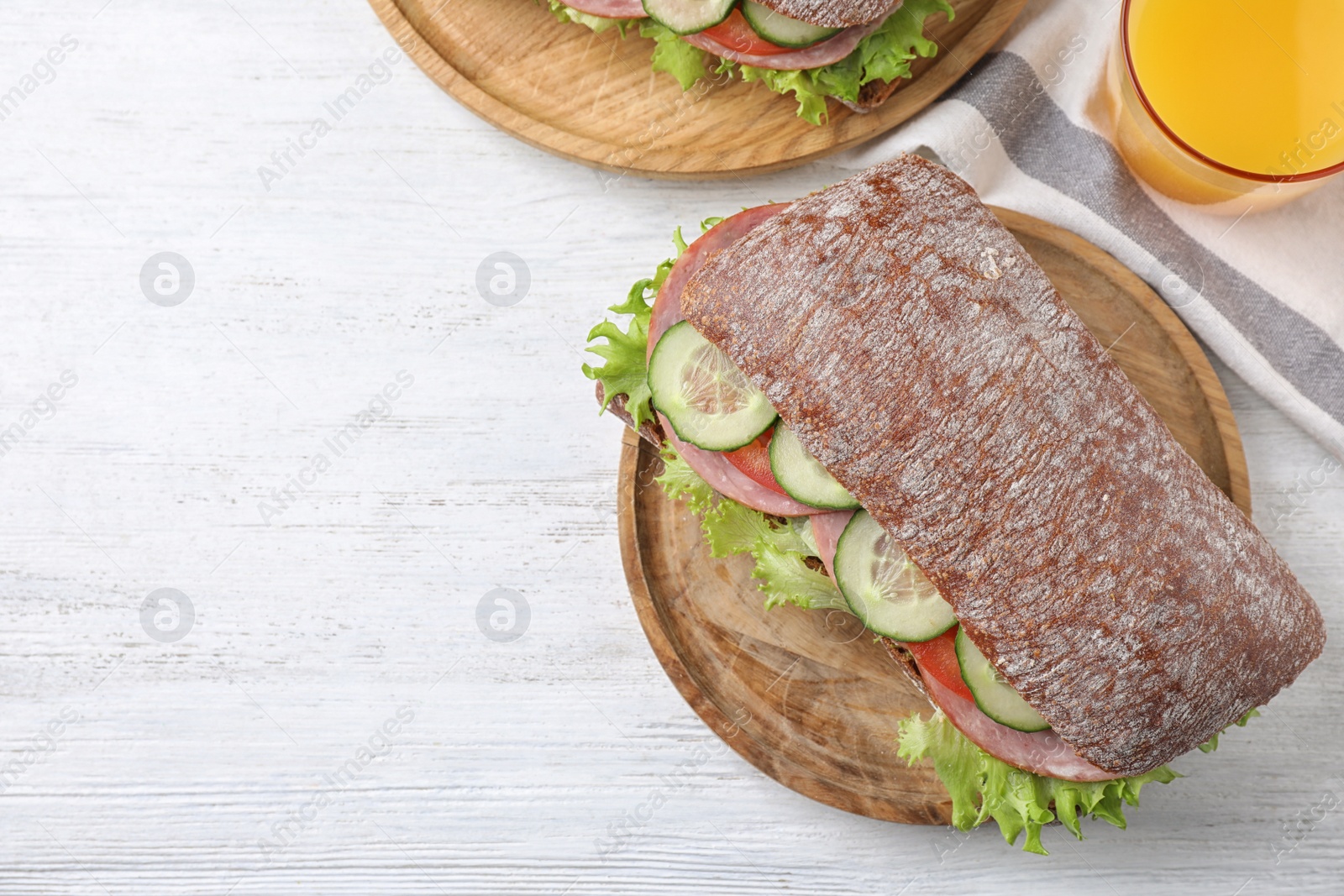 Photo of Tasty sandwich with ham served on white wooden table, flat lay. Space for text