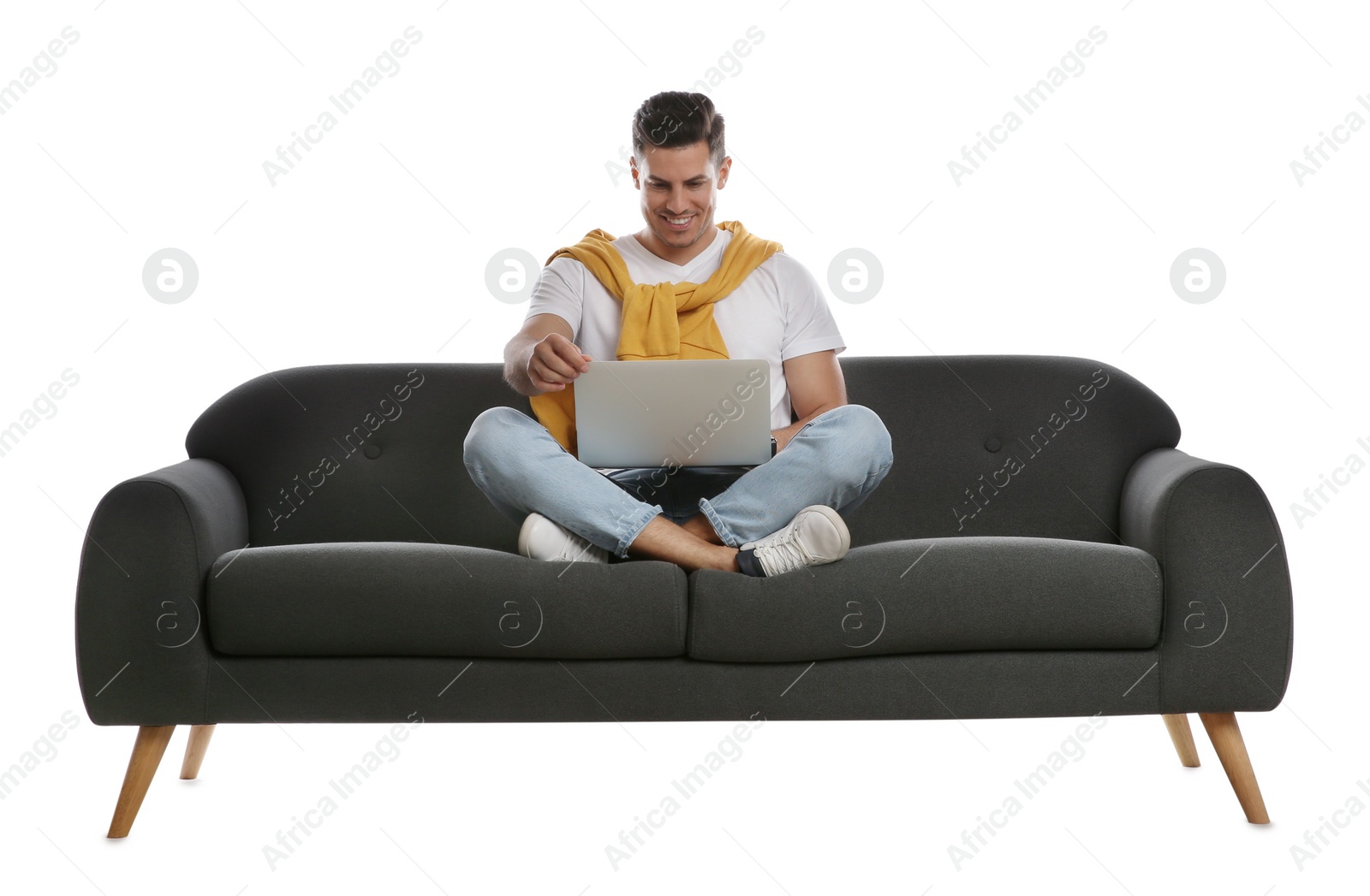 Photo of Man with laptop on comfortable grey sofa against white background