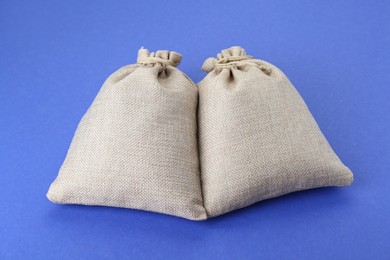 Photo of Two tied burlap bags on blue background