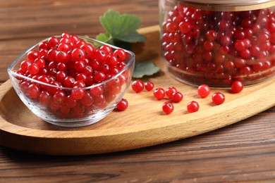 Ripe red currants and leaves on wooden table
