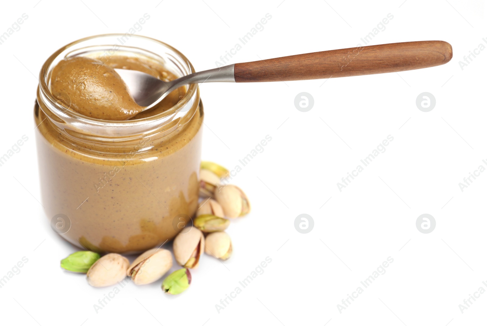 Photo of Tasty nut paste in jar, spoon and pistachios isolated on white