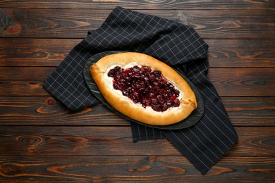Delicious sweet cottage cheese pastry with cherry jam on wooden table, top view