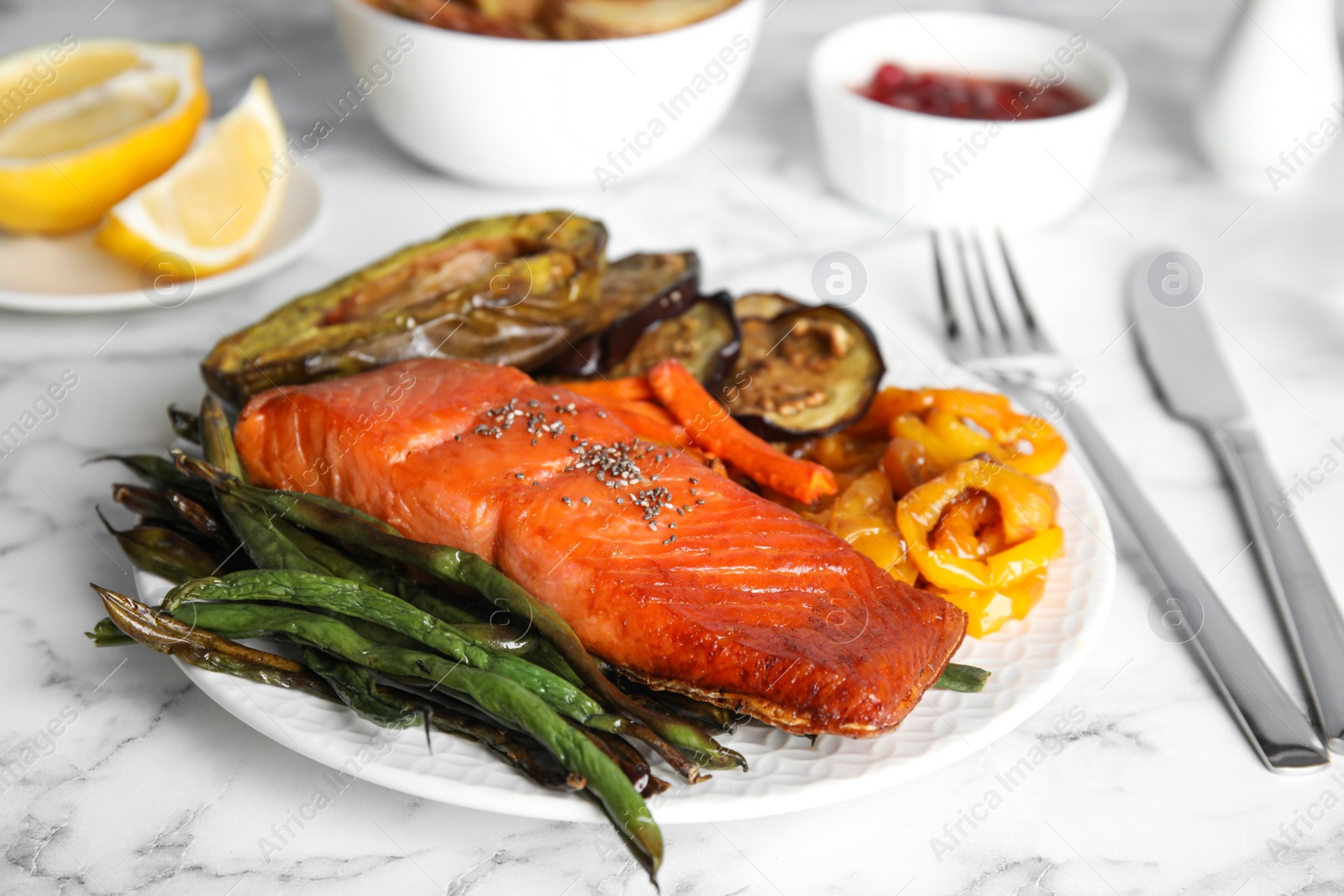 Photo of Tasty cooked salmon and vegetables served on white marble table. Healthy meals from air fryer