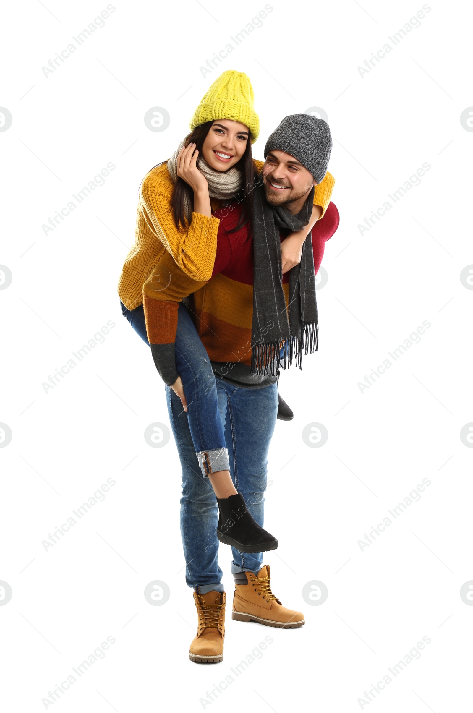 Photo of Happy young couple in warm clothes on white background. Winter vacation