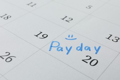 Calendar page with marked payday date as background, closeup