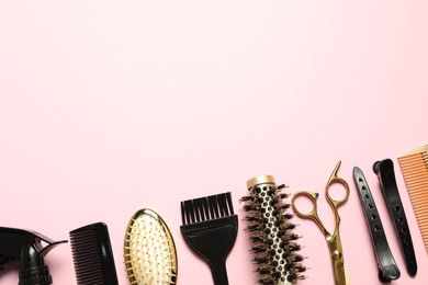 Photo of Professional hair dresser tools on pink background, flat lay. Space for text