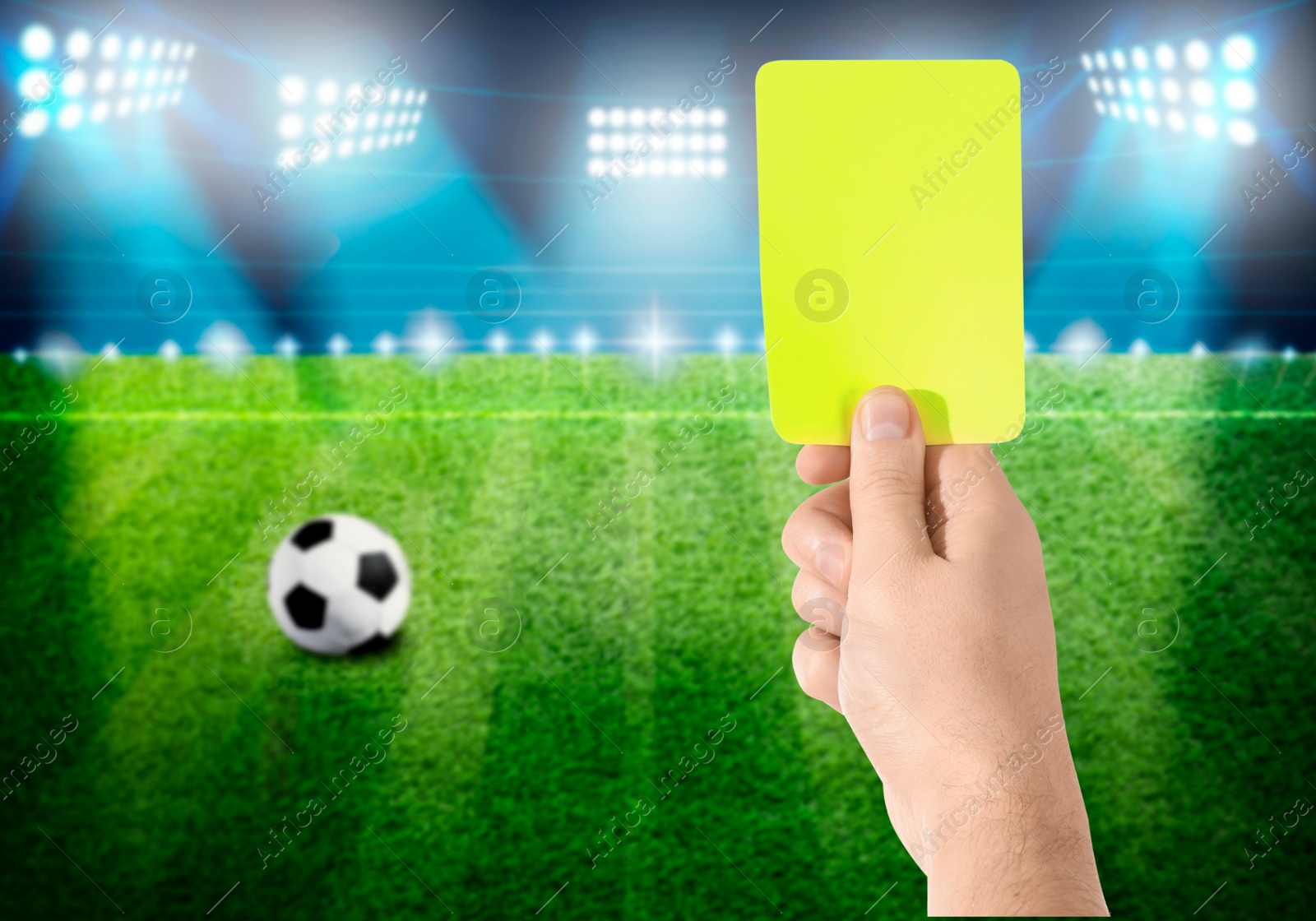 Image of Referee holding yellow card at stadium, closeup