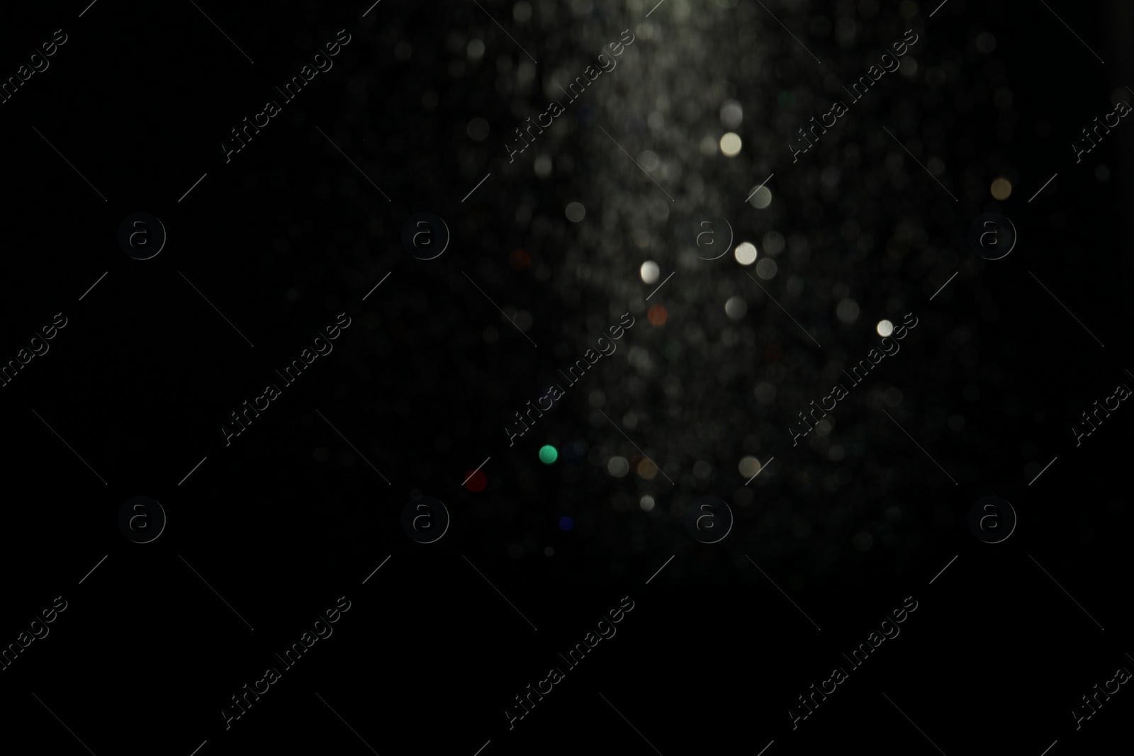 Photo of Blurred view of festive lights on black background. Bokeh effect