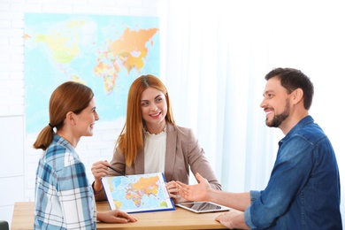 Photo of Female manager consulting couple in travel agency