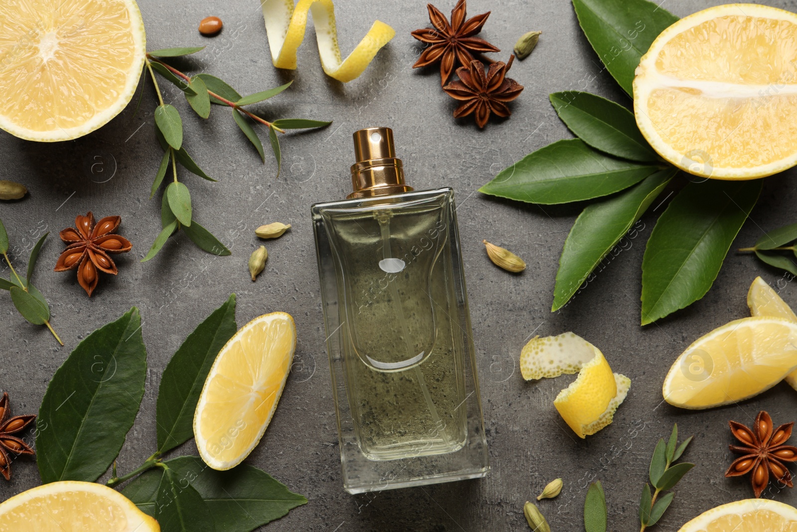 Photo of Flat lay composition with bottle of perfume and fresh citrus fruits on grey table