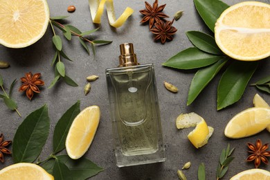 Flat lay composition with bottle of perfume and fresh citrus fruits on grey table