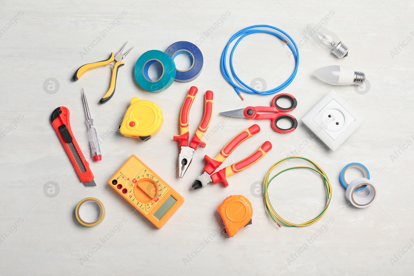 Photo of Flat lay composition with electrician's tools on light background