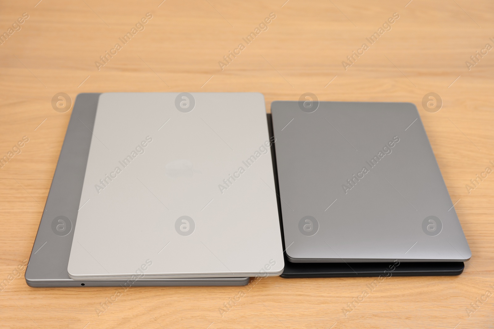 Photo of Different laptops on wooden table. Modern technology