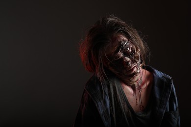 Photo of Scary zombie on dark background, space for text. Halloween monster