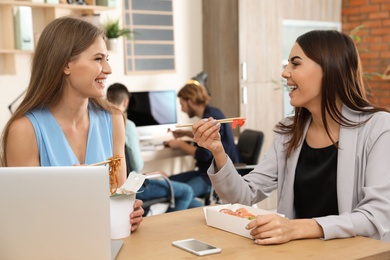 Photo of Office employees having lunch at workplace. Food delivery