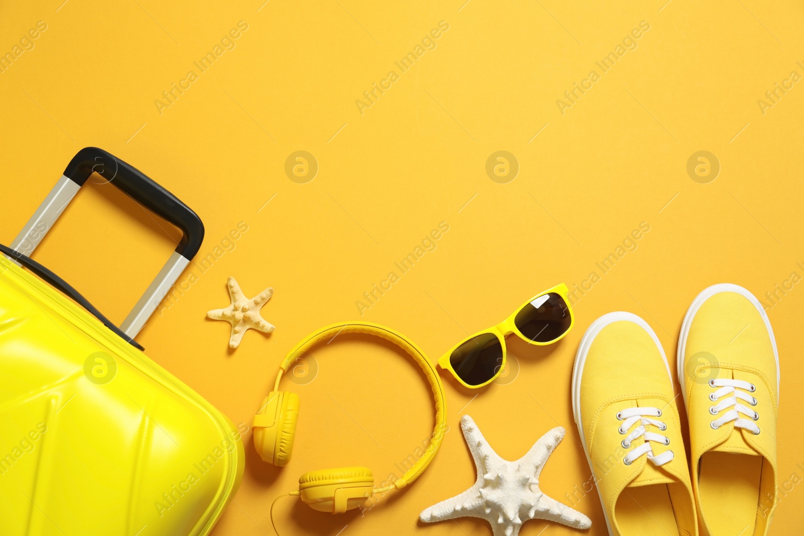 Photo of Flat lay composition with suitcase on color background, space for text. Beach accessories