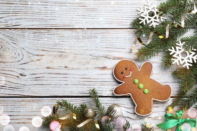 Flat lay composition with gingerbread man on white wooden table, space for text