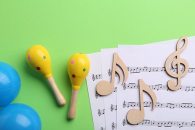 Photo of Tools for creating baby songs. Flat lay composition with maracas on green background