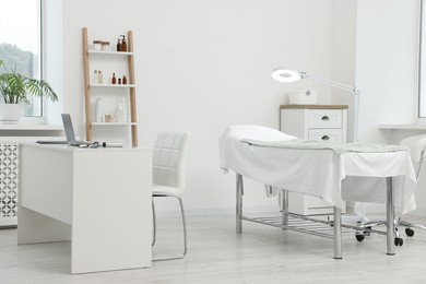 Photo of Modern interior of dermatologist's office with examination table