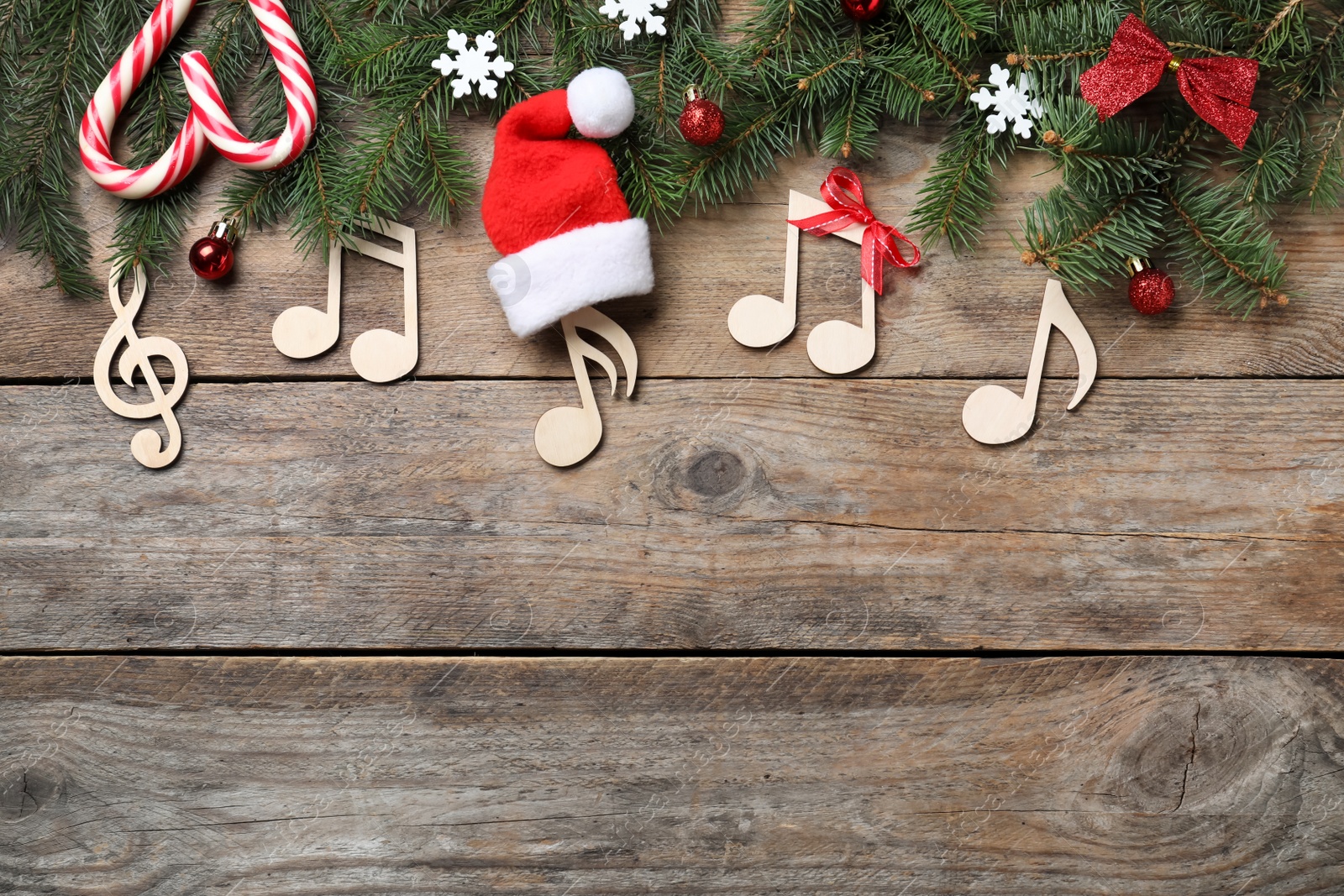 Photo of Flat lay composition with music notes on wooden background, space for text. Christmas celebration