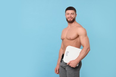 Photo of Athletic man holding scales on light blue background, space for text. Weight loss concept