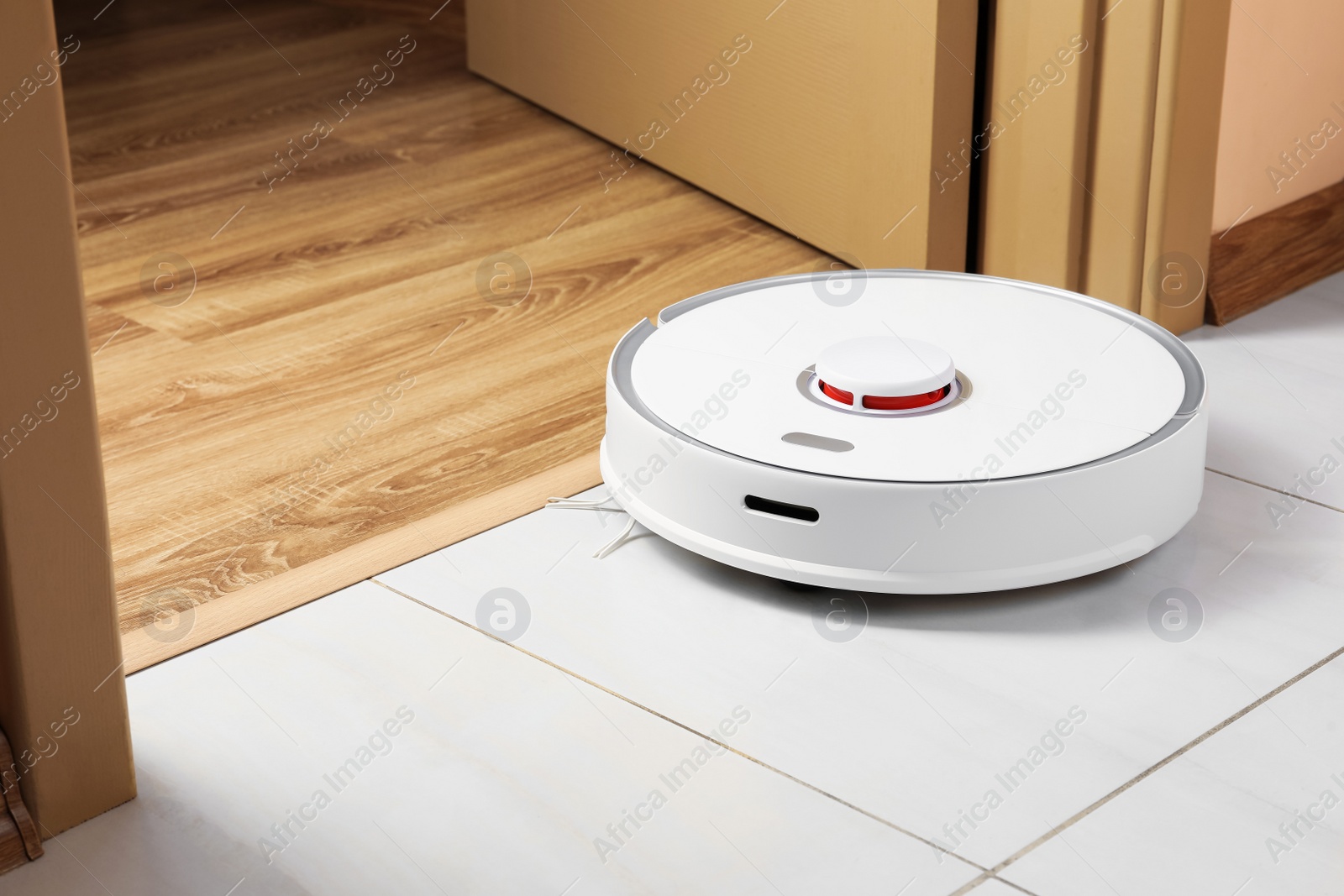 Photo of Modern robotic vacuum cleaner on white floor indoors