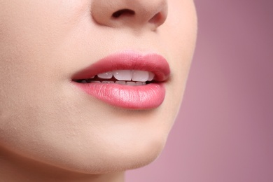 Photo of Beautiful young woman with perfect lips makeup on color background, closeup