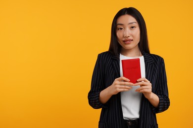 Immigration. Woman with passport on orange background, space for text