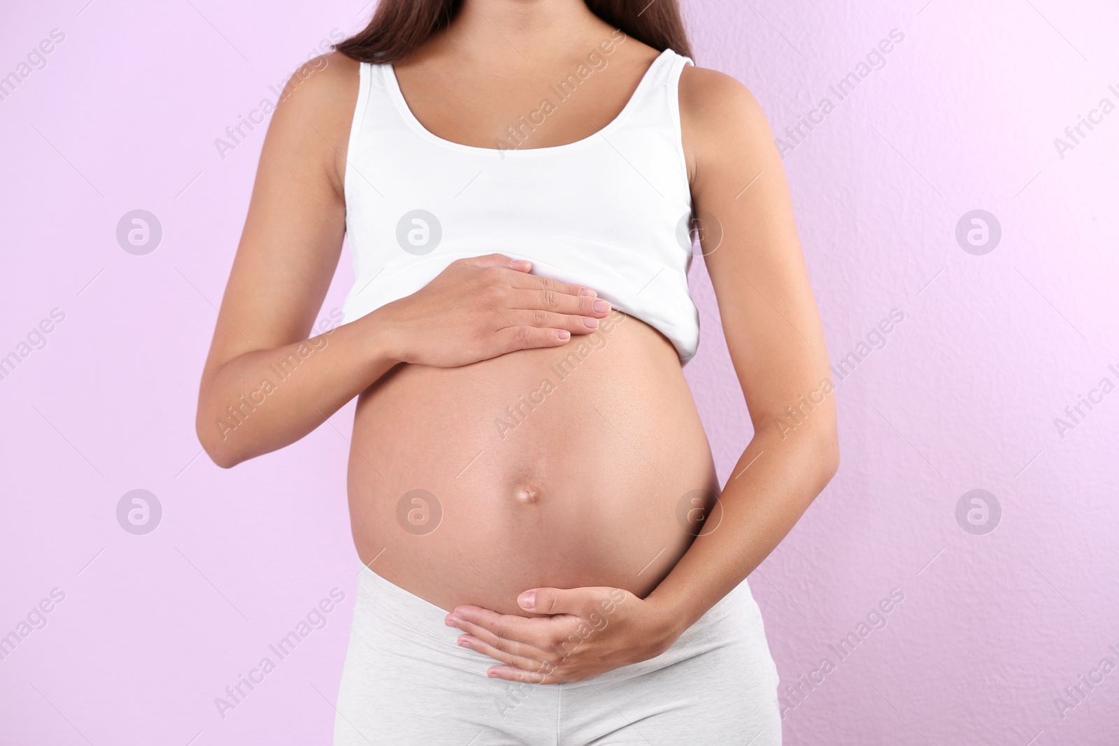 Photo of Pregnant woman posing on color background, closeup