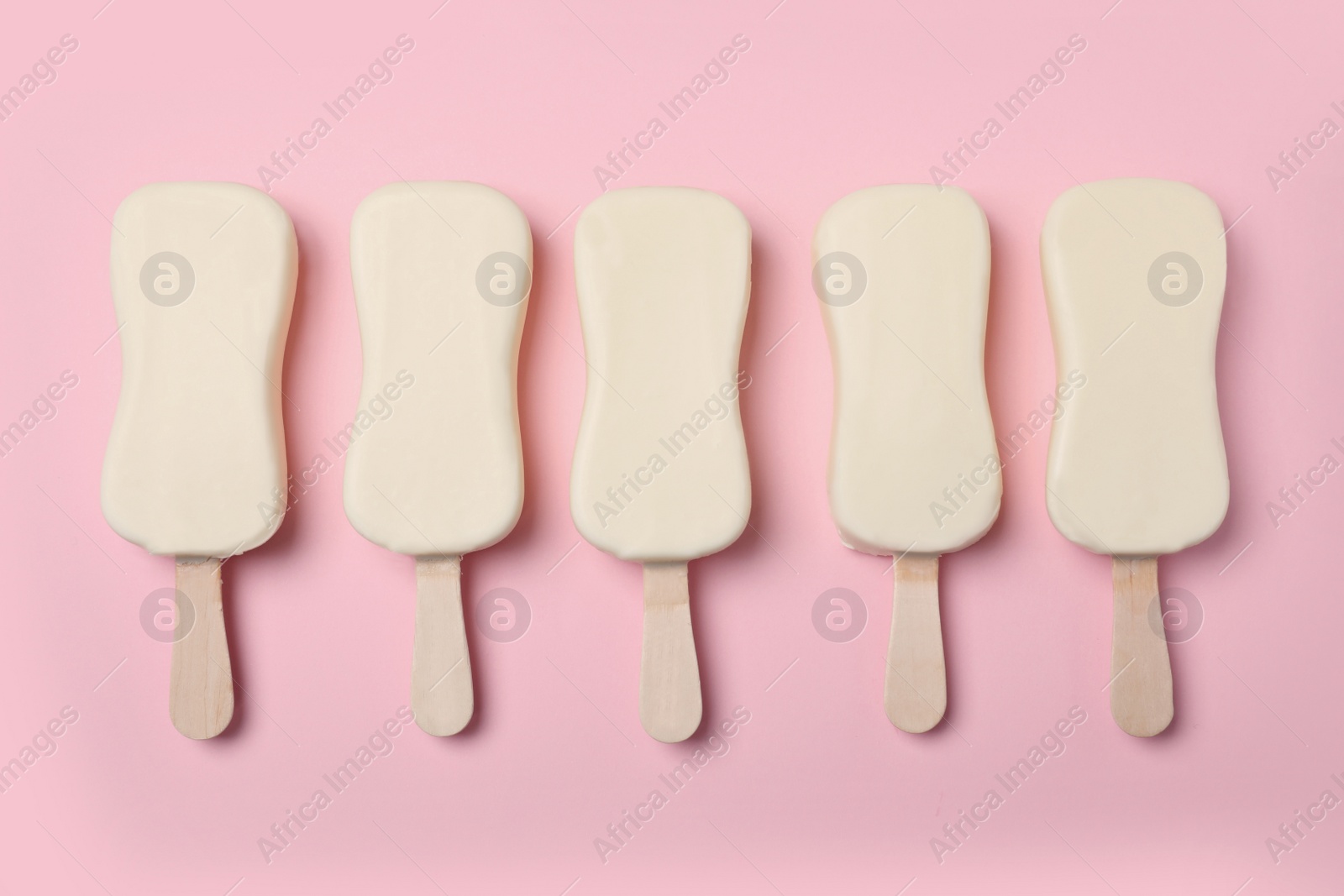 Photo of Glazed ice cream bars on pink background, flat lay