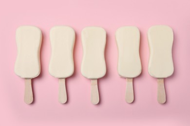 Glazed ice cream bars on pink background, flat lay