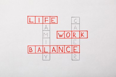Photo of Crossword drawn on white background. Life and work balance concept