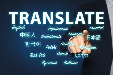Image of Translator pointing at virtual screen with names of different languages on dark blue background, closeup