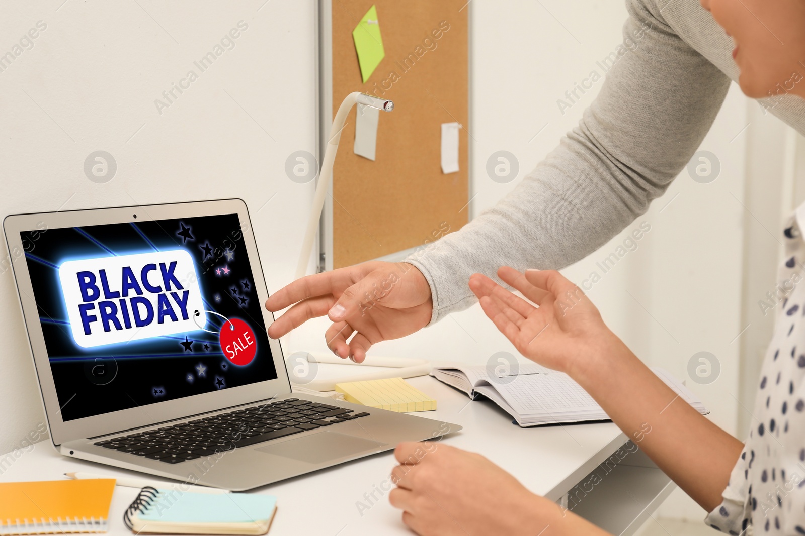 Image of Black Friday. People shopping online using laptop at table, closeup