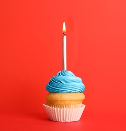 Photo of Birthday cupcake with candle on red background