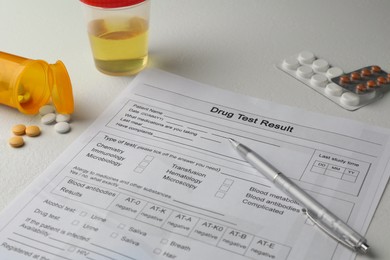 Photo of Drug test result form, container with urine sample and pills on light table