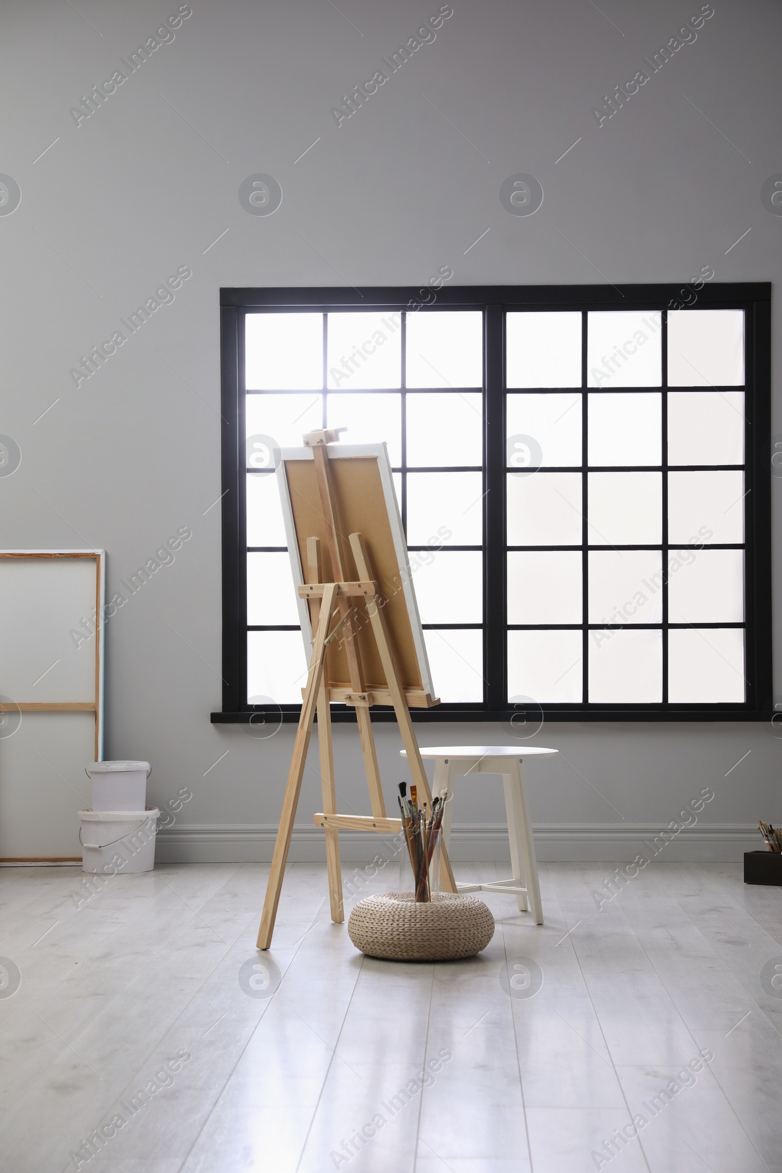 Photo of Stylish artist's studio interior with easel and brushes