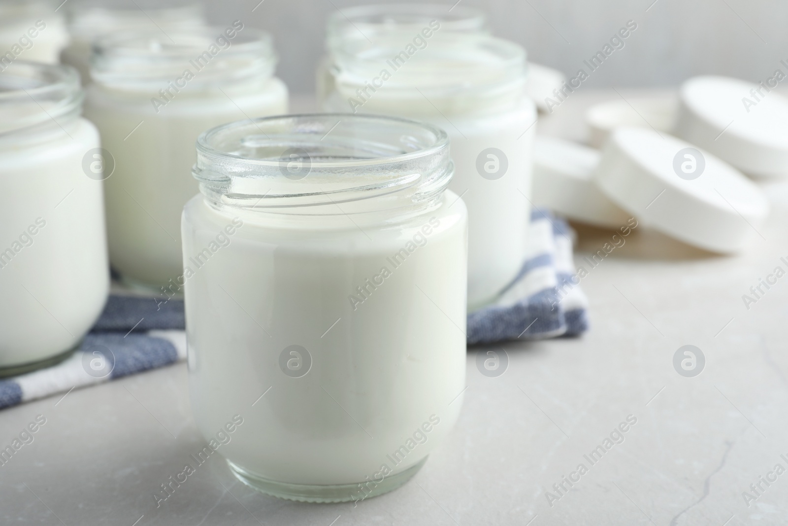 Photo of Tasty yogurt on light grey marble table, closeup