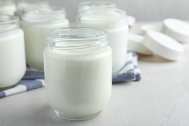 Tasty yogurt on light grey marble table, closeup