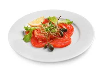 Photo of Salmon carpaccio with capers, lettuce, microgreens and lemon isolated on white