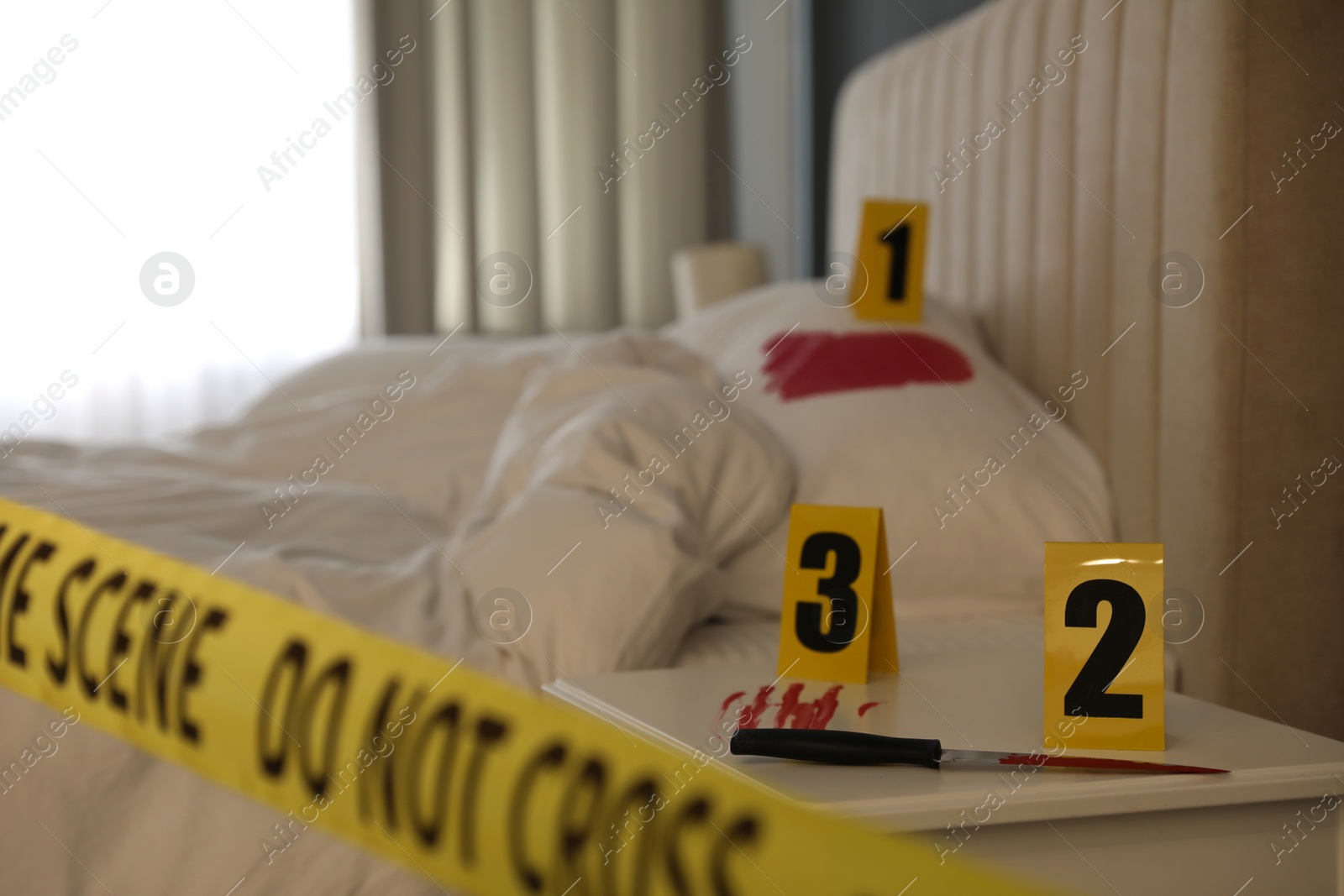 Photo of Bloody knife and crime scene markers on nightstand in bedroom