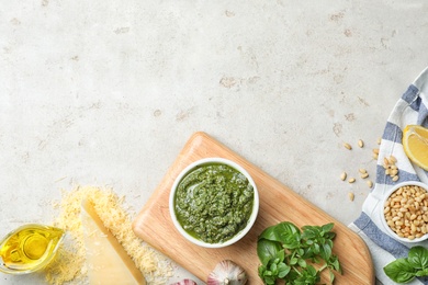 Flat lay composition with homemade basil pesto sauce and ingredients on table. Space for text