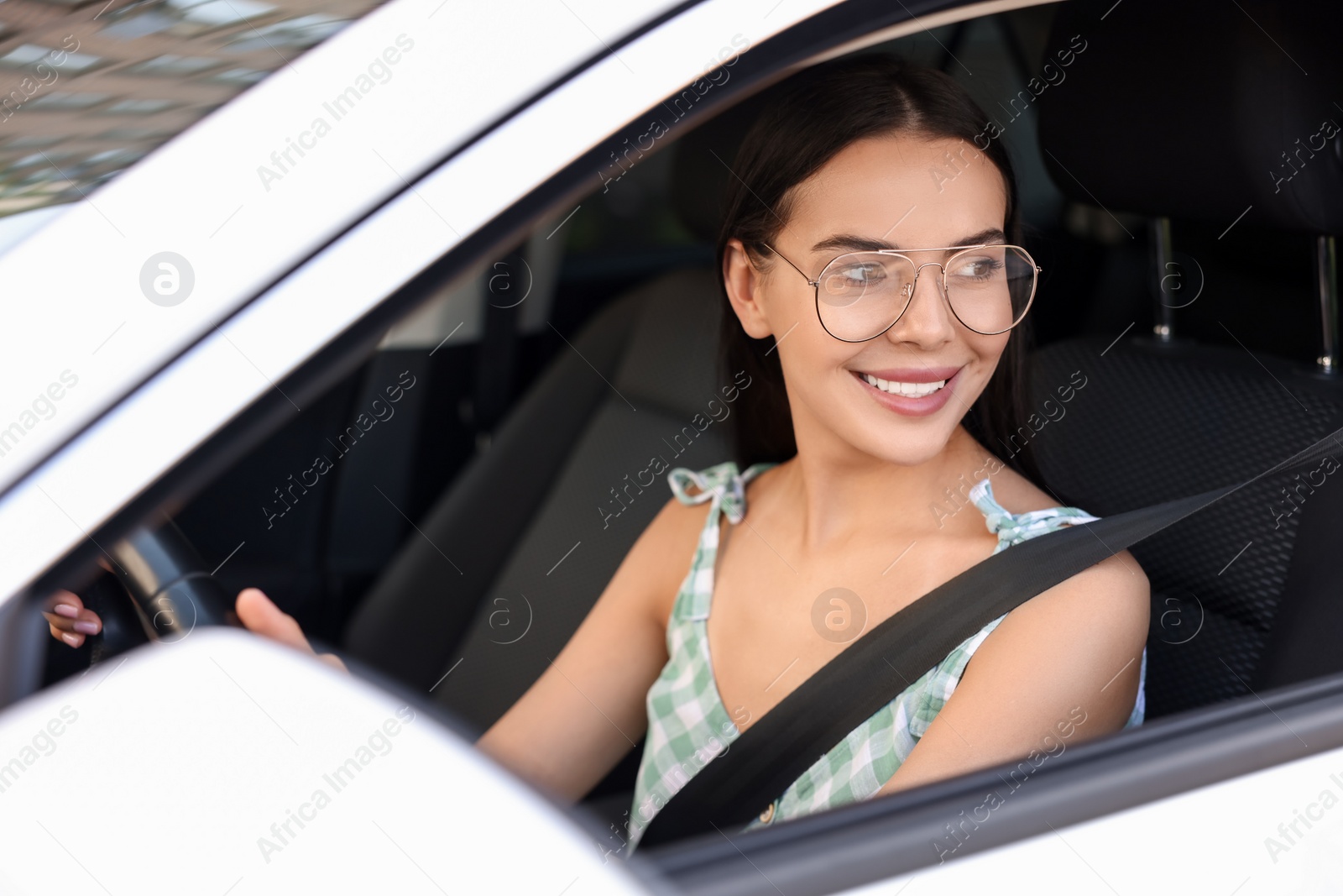 Photo of Enjoying trip. Happy young woman in car, view from outside