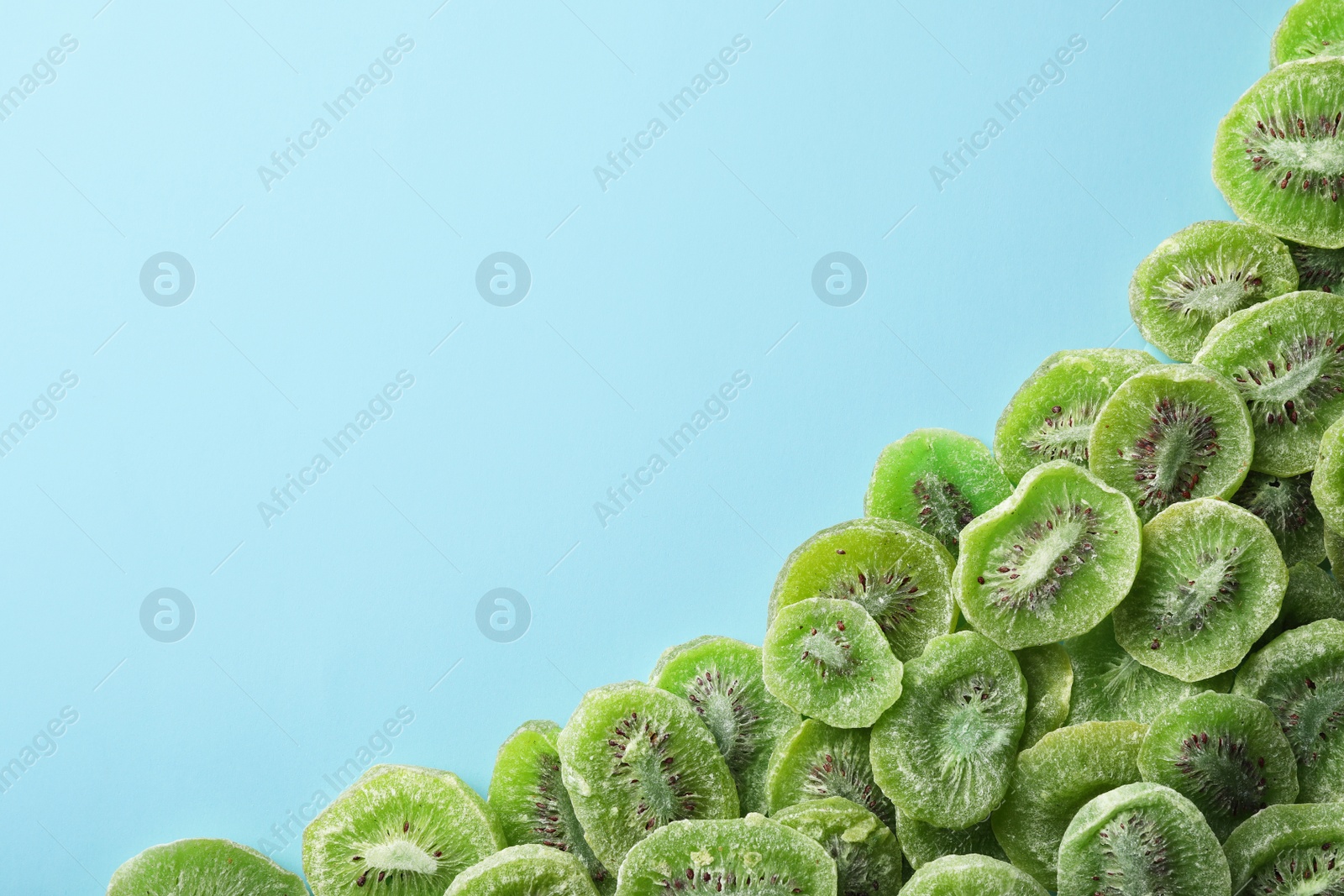 Photo of Frame made of kiwi on color background, top view with space for text. Dried fruit as healthy food