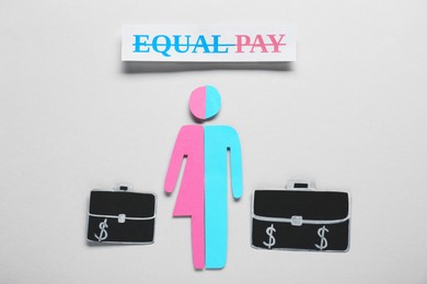 Photo of Equal pay concept. Human paper figure as male and female halves against light grey background, flat lay
