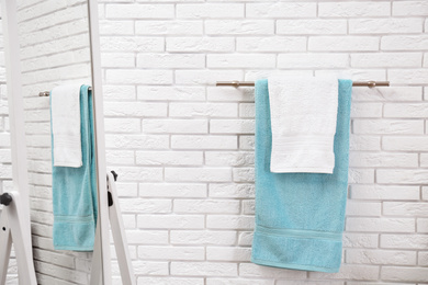 Photo of Fresh clean towels on hanger in bathroom