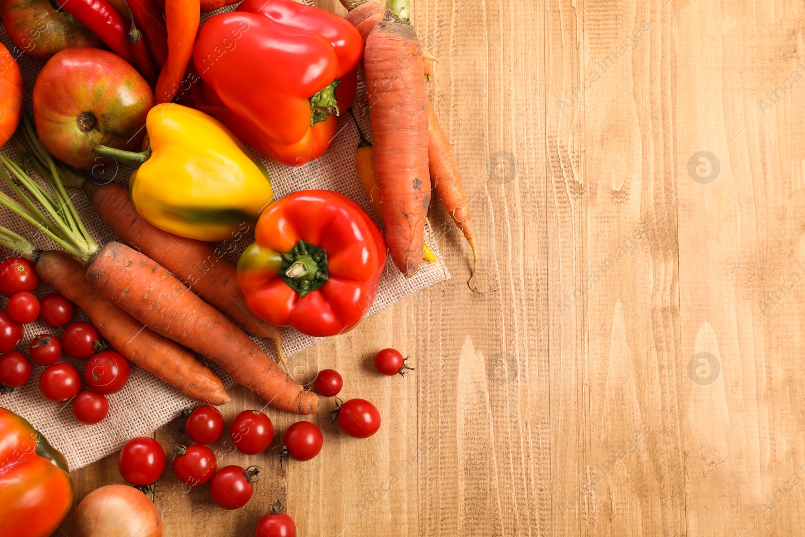 Photo of Different fresh ripe vegetables on wooden table, flat lay. Space for text